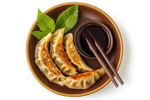 Chinese dumplings with sauce and chopsticks on a plate photo