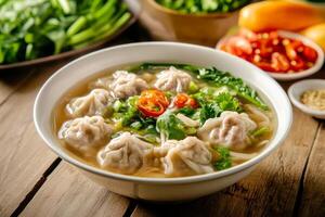 A bowl of soup with dumplings and vegetables photo