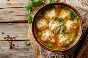 A bowl of soup with dumplings and herbs photo