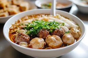 A bowl of soup with meatballs and noodles photo