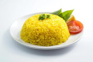 A plate of yellow rice with a tomato and parsley photo