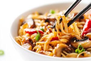 Chopsticks are holding noodles in a bowl photo