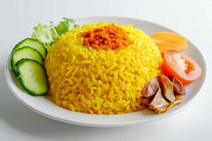 A plate of yellow rice with vegetables and meat photo