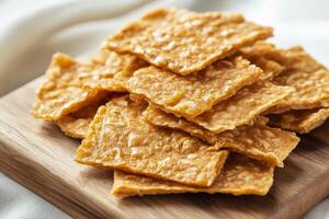 A pile of crackers on a wooden cutting board photo