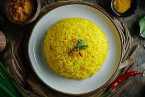 Yellow rice with chili and spices on a wooden table photo