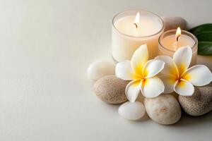 Spa stones and candles with frangipani flower on white background photo