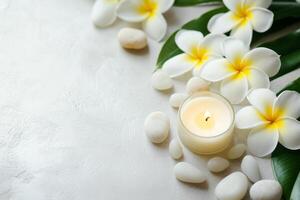 White flowers and stones with a candle on a white background photo
