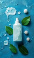 A bottle of soap and green leaves on a blue background photo