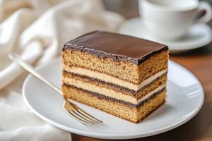 A piece of cake on a plate with a fork photo