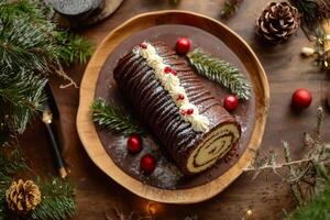 A chocolate roll with cream and pine cones on a wooden table photo