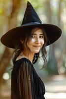 A woman in a black witch hat smiling photo