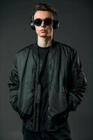 Portrait of a young man in black jacket and sunglasses on a dark background photo