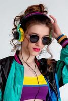 A woman in a jacket and sunglasses wearing headphones photo