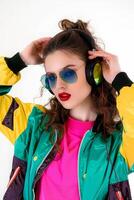 A woman in sunglasses and a colorful jacket with headphones photo