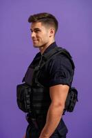 A man in a vest standing against a purple background photo