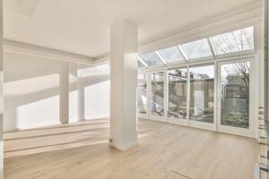 An empty room with a large window and wooden floors photo