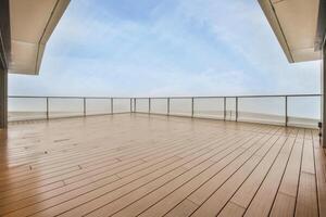A balcony with wooden flooring and a view of the sky photo