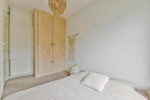 A bedroom with a bed, a wardrobe and a window photo