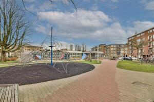 A playground with a swing set and a tree photo