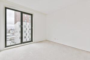 An empty room with a large window and white walls photo