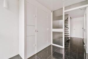 A hallway with a staircase and white cabinets photo