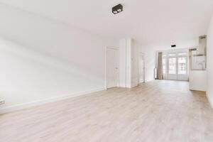 An empty room with white walls and wooden floors photo