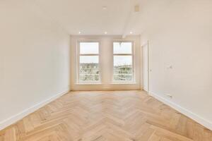 An empty room with white walls and wooden floors photo