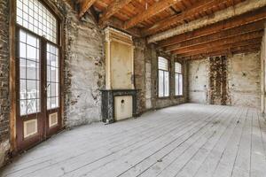An empty room with wood floors and a fireplace photo