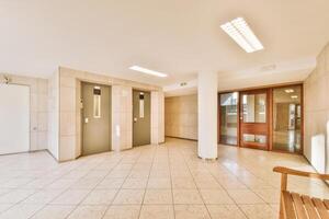 An empty hallway with two doors and a bench photo