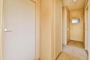 A hallway with two doors and a light switch photo