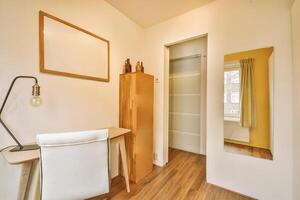 A small room with a desk and a mirror photo