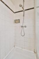 A shower with a shower head and a shower curtain photo