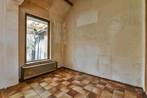 An empty room with a window and a tiled floor photo