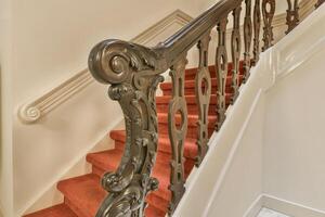 A staircase with a red carpet and white walls photo