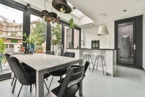 A kitchen with a table and chairs in front of a large window photo