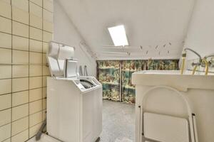 A bathroom with a washing machine and a sink photo