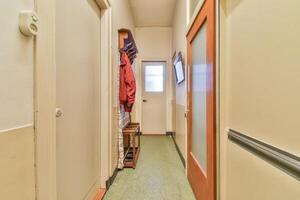 A hallway with a coat rack and a door photo