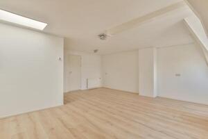 An empty room with wooden floors and white walls photo