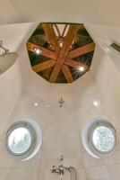 A bathroom with a shower and two windows photo