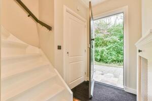 A white door with a white door handle and a white staircase photo
