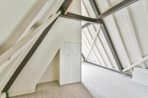 A white attic with a door and a window photo