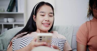 Handheld dolly shot, Two happy women are enjoying watching something together on mobile phone in living room at home. Happy family time ,Having fun on weekend video