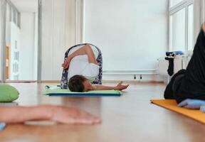 Senior Woman Practicing Back Stretches in a Sunlit Space for Optimal Health and Well Being photo