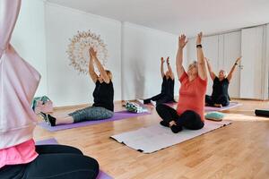 A group of senior women engage in various yoga exercises, including neck, back, and leg stretches, under the guidance of a trainer in a sunlit space, promoting well-being and harmony photo