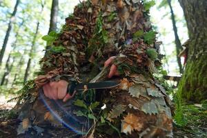 elite camouflaged sniper sharpens focus and readies for battle in the dense forest, embodying precision, stealth, and expertise as they prepare for a mission in the woodland environment photo
