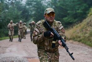 A group of elite soldiers leads captives through a military camp, showcasing a tense atmosphere of detention and security operations photo