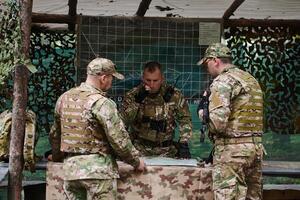 A highly trained military unit strategizes and organizes a tactical mission while studying a military map during a briefing session photo