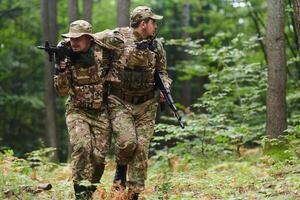 Elite soldier displays unwavering camaraderie and compassion as he aids his injured comrade, skillfully extracting him from the forest with a stretcher, showcasing the profound bond and selflessness photo