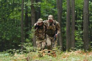 Elite soldier displays unwavering camaraderie and compassion as he aids his injured comrade, skillfully extracting him from the forest with a stretcher, showcasing the profound bond and selflessness photo
