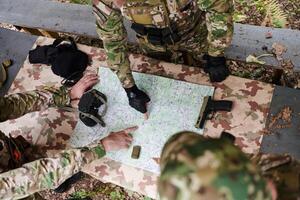 A highly trained military unit strategizes and organizes a tactical mission while studying a military map during a briefing session photo